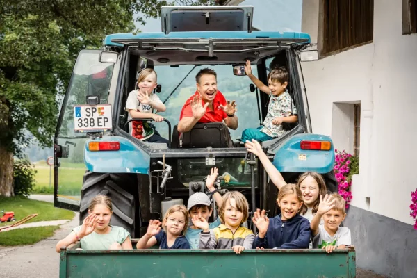 Die Kinder fahren mit dem Traktor