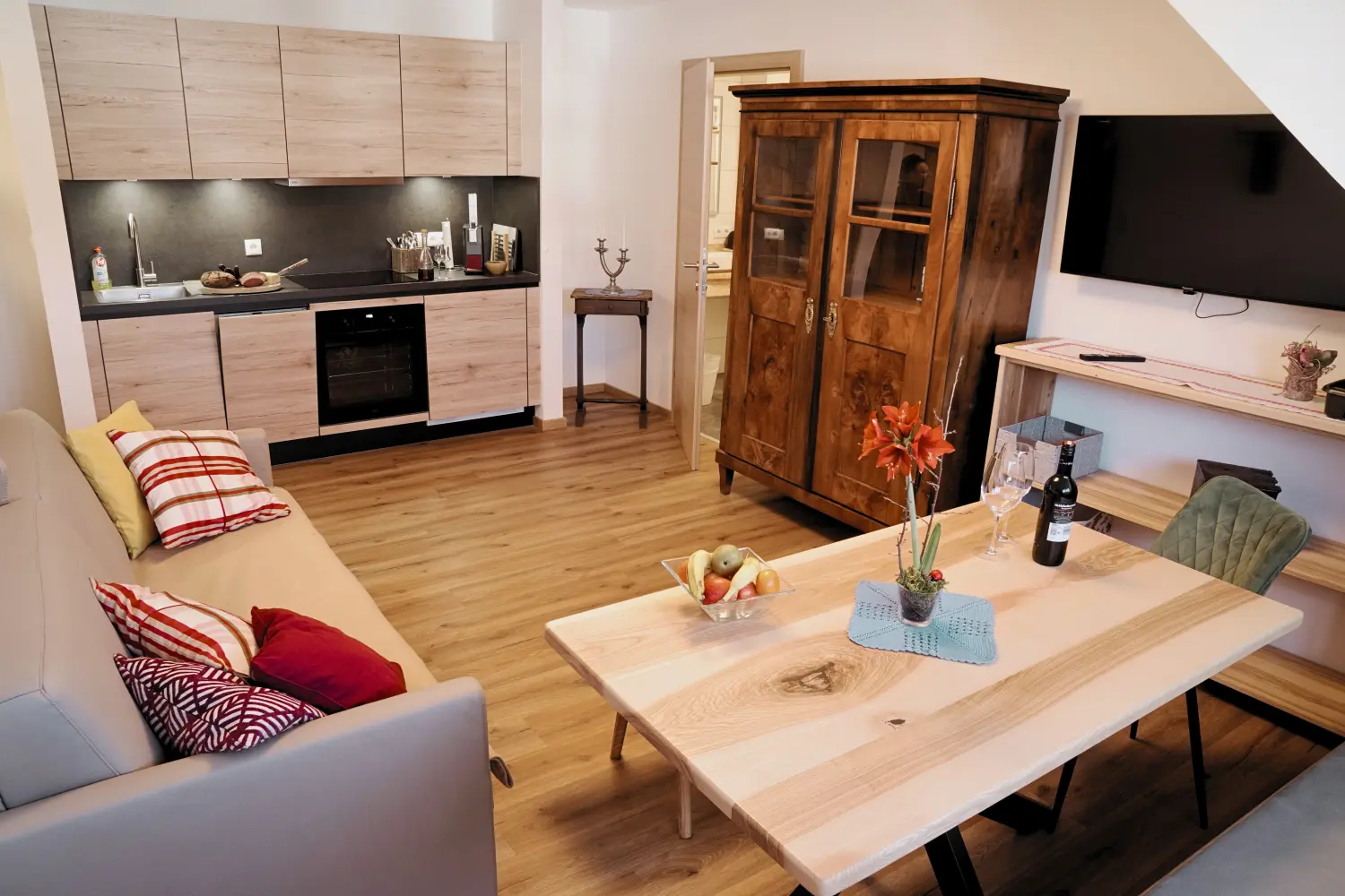 Moderne Wohnküche im Familienappartement mit Essbereich, Holzdetails und hochwertiger Ausstattung.