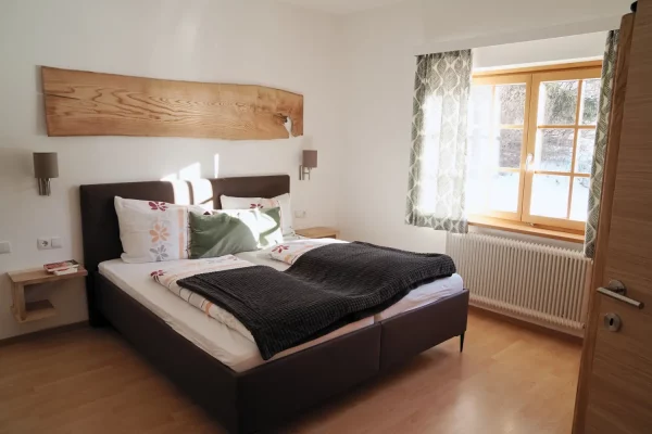 Ruhiges Schlafzimmer mit Doppelbett und viel Tageslicht.